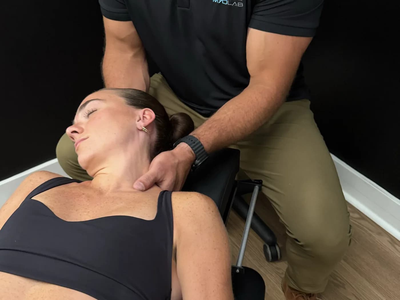 Clinician performing hands-on care on a patient's neck during a treatment session
